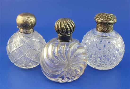 Three late Victorian silver lidded cut glass globular scent bottles, 5.25in et infra.